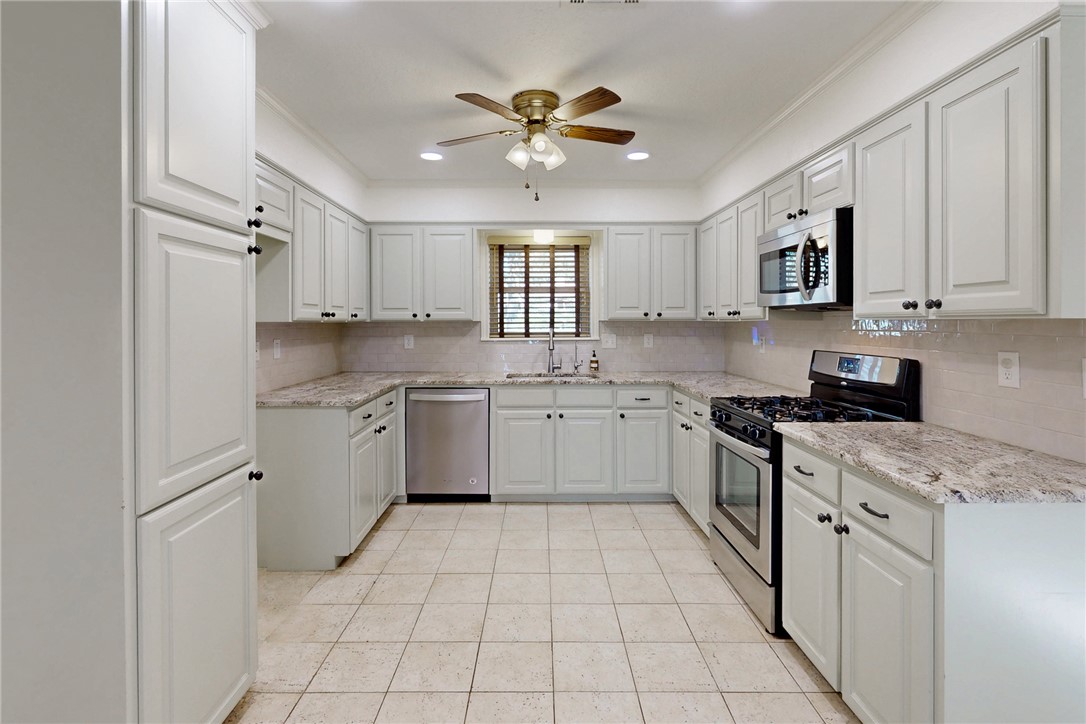 1308 Hawk Tree Drive College Station, TX 77845 - Photo 4 of 34 a kitchen with cabinets stainless steel appliances a sink and a window