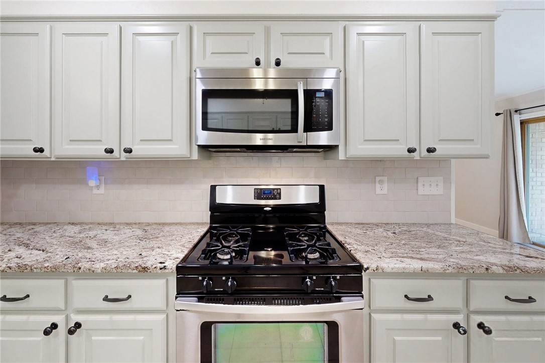 1308 Hawk Tree Drive College Station, TX 77845 - Photo 6 of 34 a kitchen with granite countertop white cabinets and stainless steel appliances