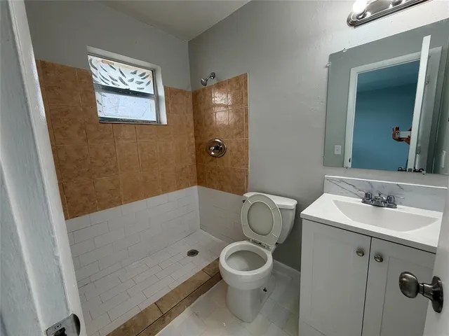 a bathroom with a granite countertop shower and a sink