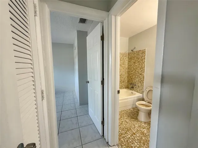 a bathroom with a granite countertop toilet a sink and a bathtub