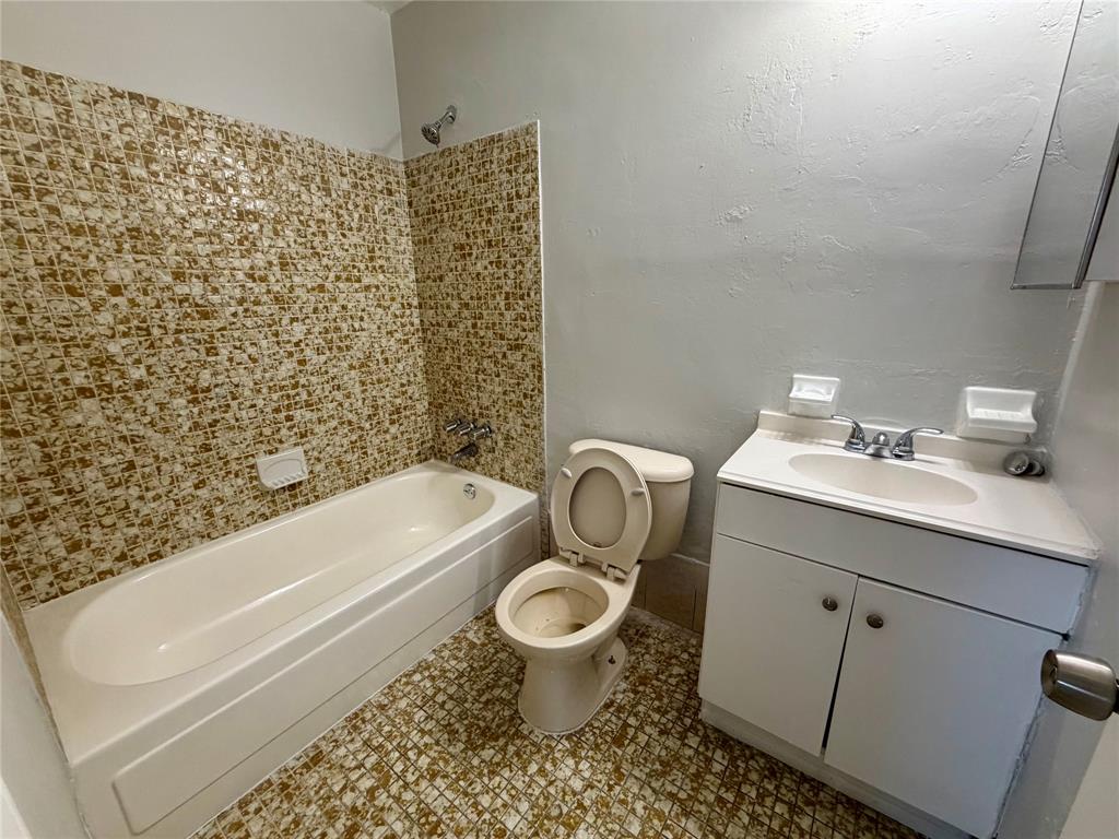 874 Southwest 10th Drive, Unit 741216 Pompano Beach, FL 33060 - Photo 14 of 16 a bathroom with a granite countertop toilet a sink and a bathtub