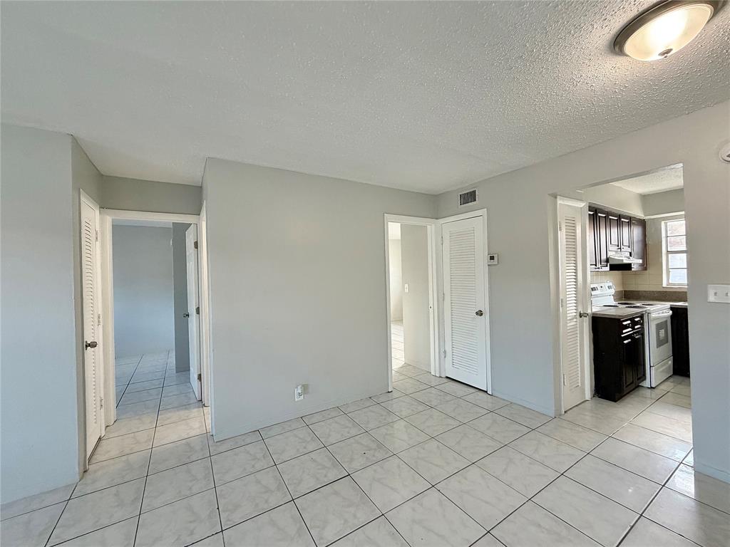 874 Southwest 10th Drive, Unit 741216 Pompano Beach, FL 33060 - Photo 4 of 16 an empty room with kitchen and entryway