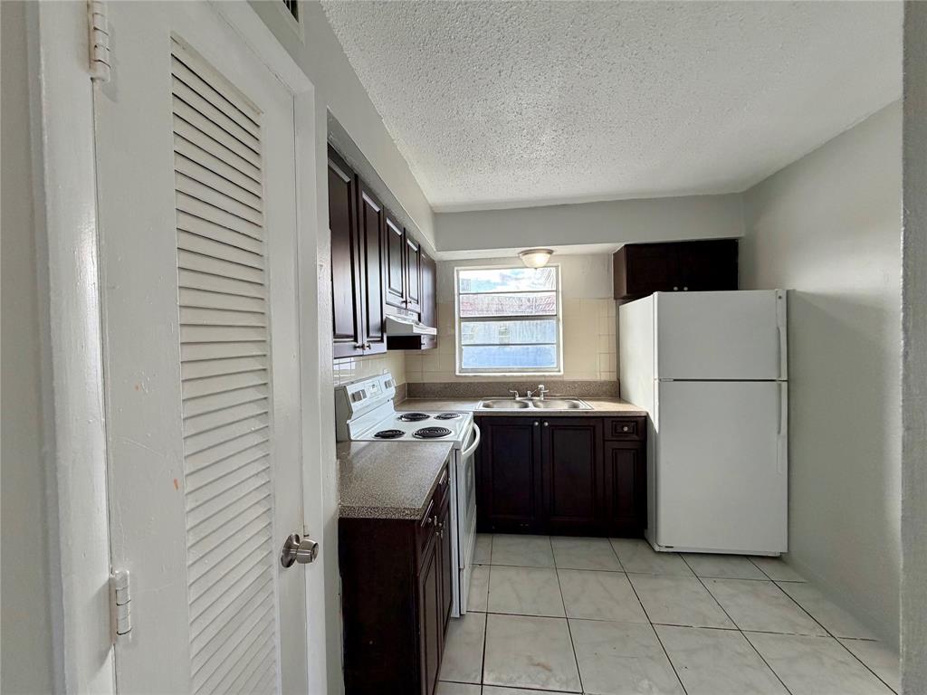 874 Southwest 10th Drive, Unit 741216 Pompano Beach, FL 33060 - Photo 6 of 16 a kitchen with a refrigerator and a stove