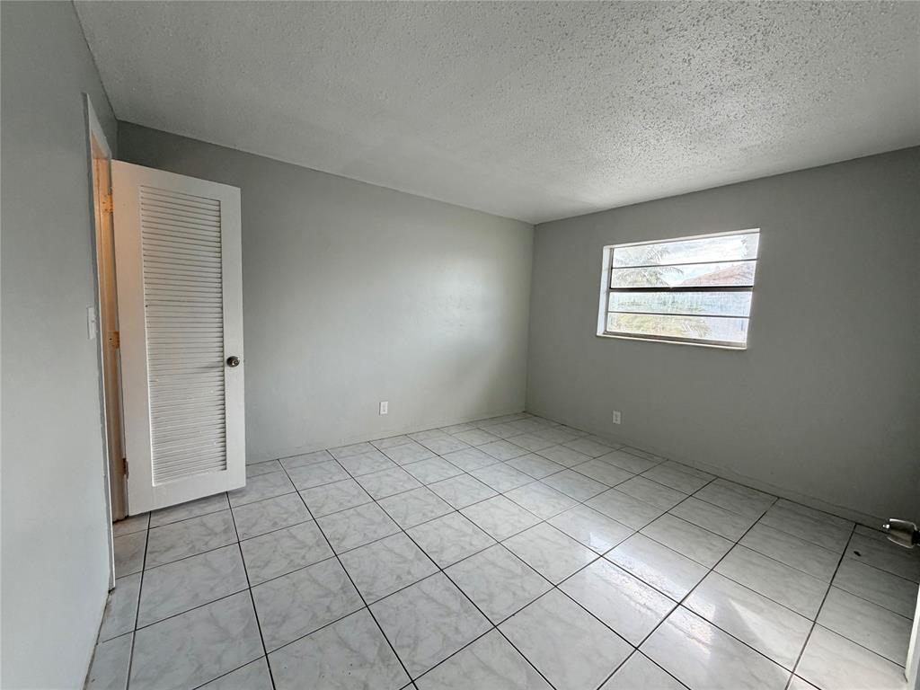 874 Southwest 10th Drive, Unit 741216 Pompano Beach, FL 33060 - Photo 8 of 16 an empty room with windows