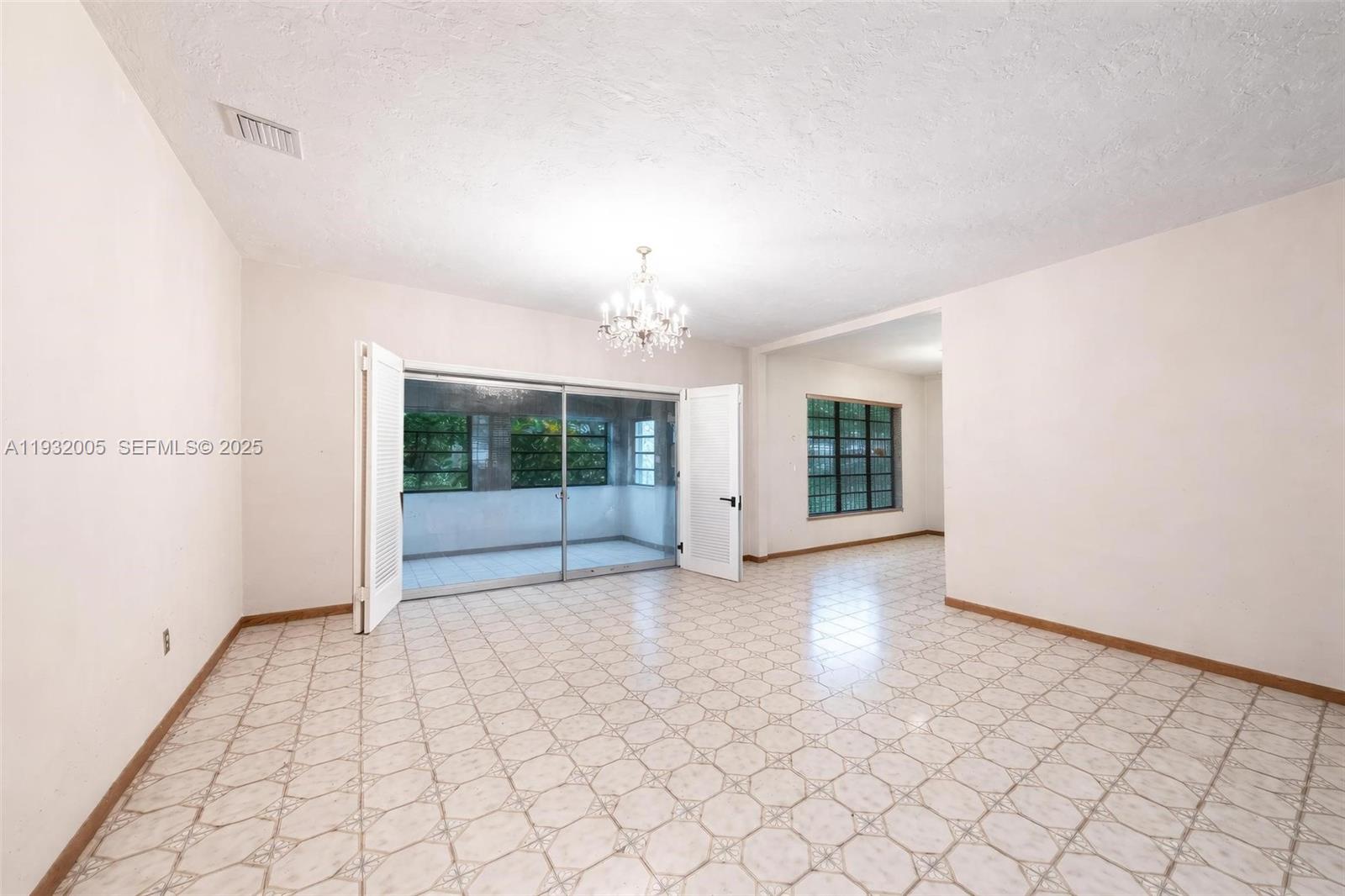8230 Southwest 117th Terrace Miami, FL 33156 - Photo 7 of 18 an empty room with windows and chandelier
