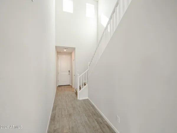 a view of a hallway with wooden floor and a white wall