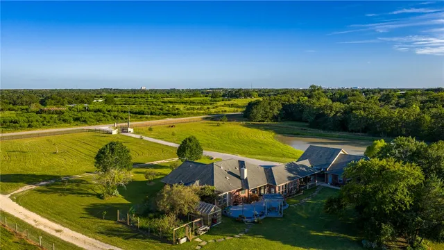 an aerial view of a house with a swimming pool outdoor seating and yard