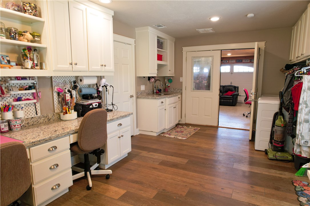 6045 Old Reliance Road Bryan, TX 77808 - Photo 29 of 50 a kitchen that has a lot of cabinets and wooden floor