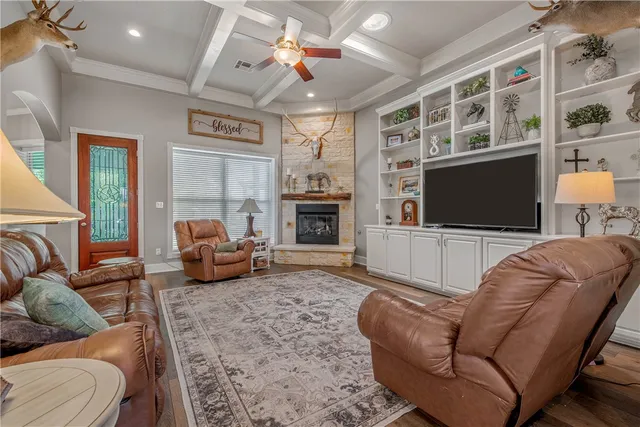 a living room with furniture a flat screen tv and a fireplace