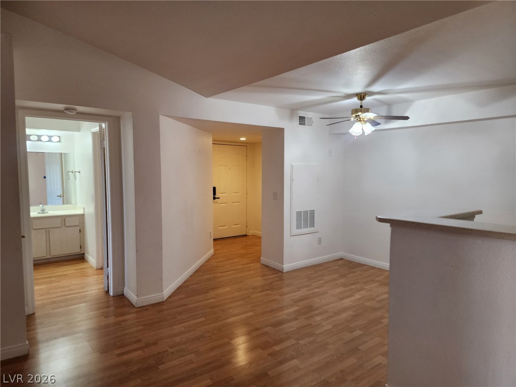 231 West Horizon Ridge Parkway, Unit 1127 Henderson, NV 89012 - Photo 30 of 39 A versatile open-plan area features wood flooring, a ceiling fan, and access to the bathroom and entry.