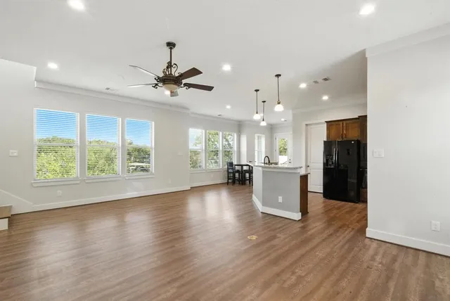 an open kitchen with white cabinets and wooden floor