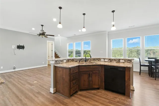 a kitchen with a stove and wooden floor