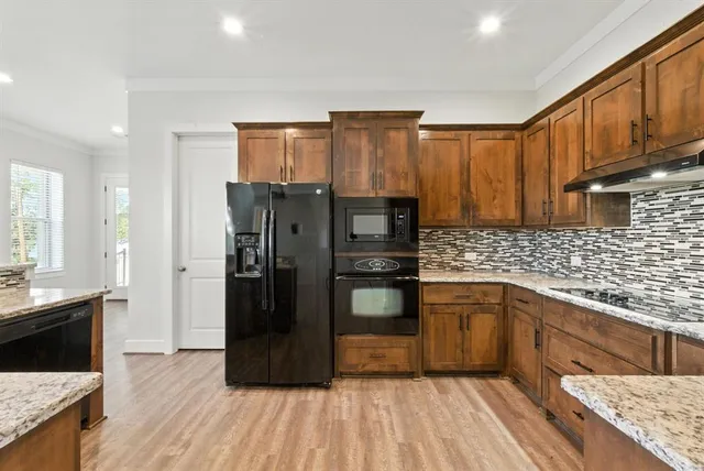 a kitchen with stainless steel appliances granite countertop a refrigerator and a sink
