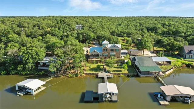 an aerial view of a house with a garden and lake view