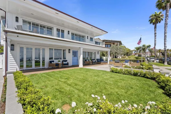 a view of a building with a big yard and large trees