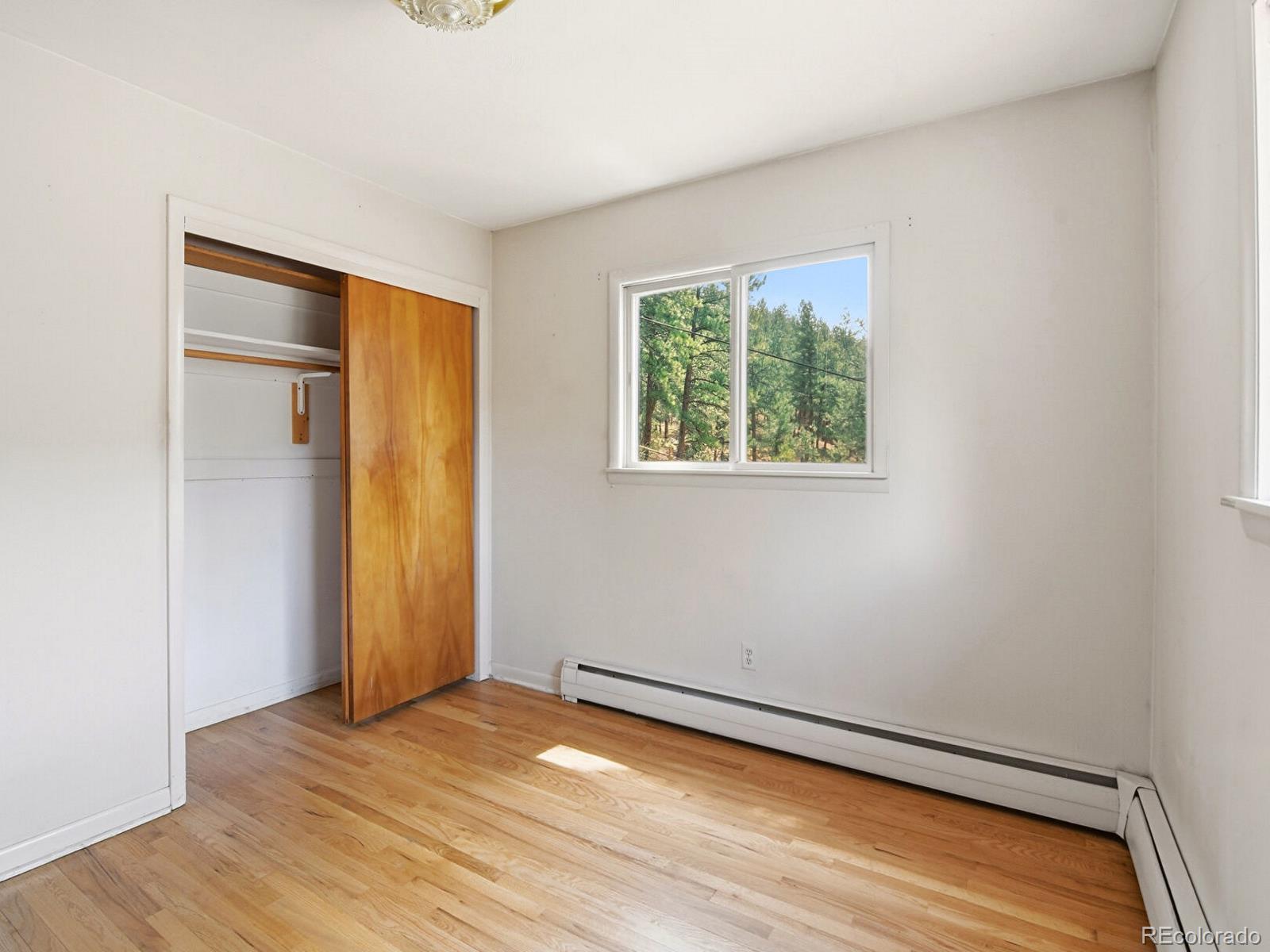 2830 Kerr Gulch Road Evergreen, CO 80439 - Photo 22 of 48 an empty room with wooden floor and windows