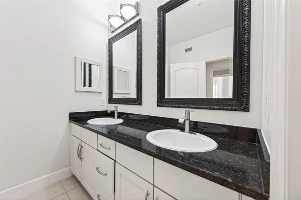 a bathroom with double sink and a mirror