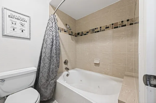 a white bath tub sitting next to a white toilet and sink