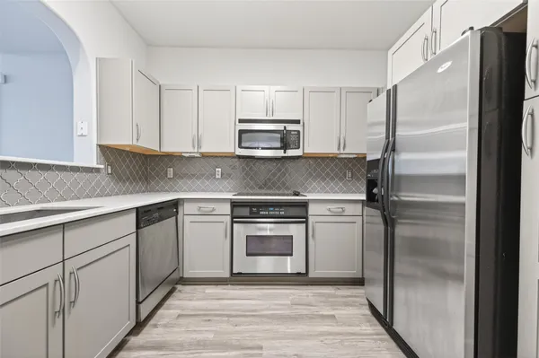 a kitchen with a refrigerator sink and cabinets