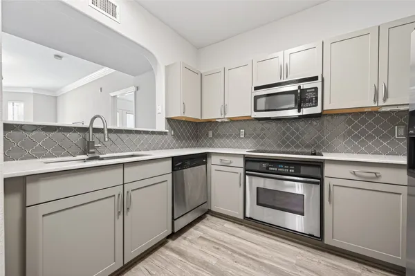a kitchen with stainless steel appliances granite countertop a sink stove and microwave