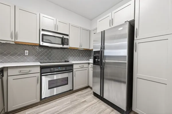 a kitchen with white cabinets and stainless steel appliances