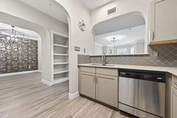 a kitchen with stainless steel appliances granite countertop a sink and cabinets with wooden floor