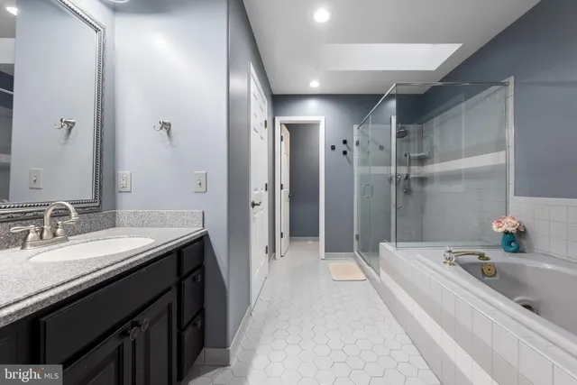 a bathroom with a tub sink and mirror
