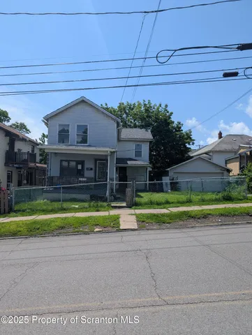 a front view of a house with a yard and trees