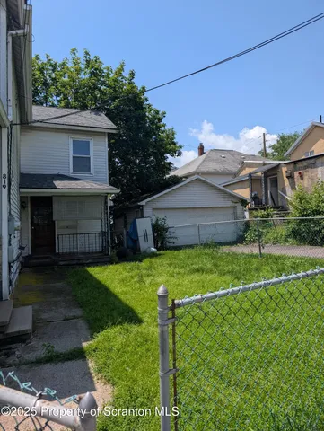 a view of a house with backyard and a garden
