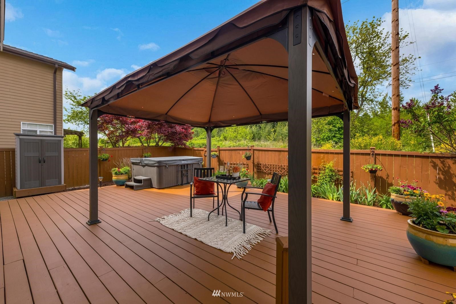16218 Southeast 249th Place Covington, WA 98042 - Photo 31 of 38 a view of a roof deck with table and chairs under an umbrella with wooden floor