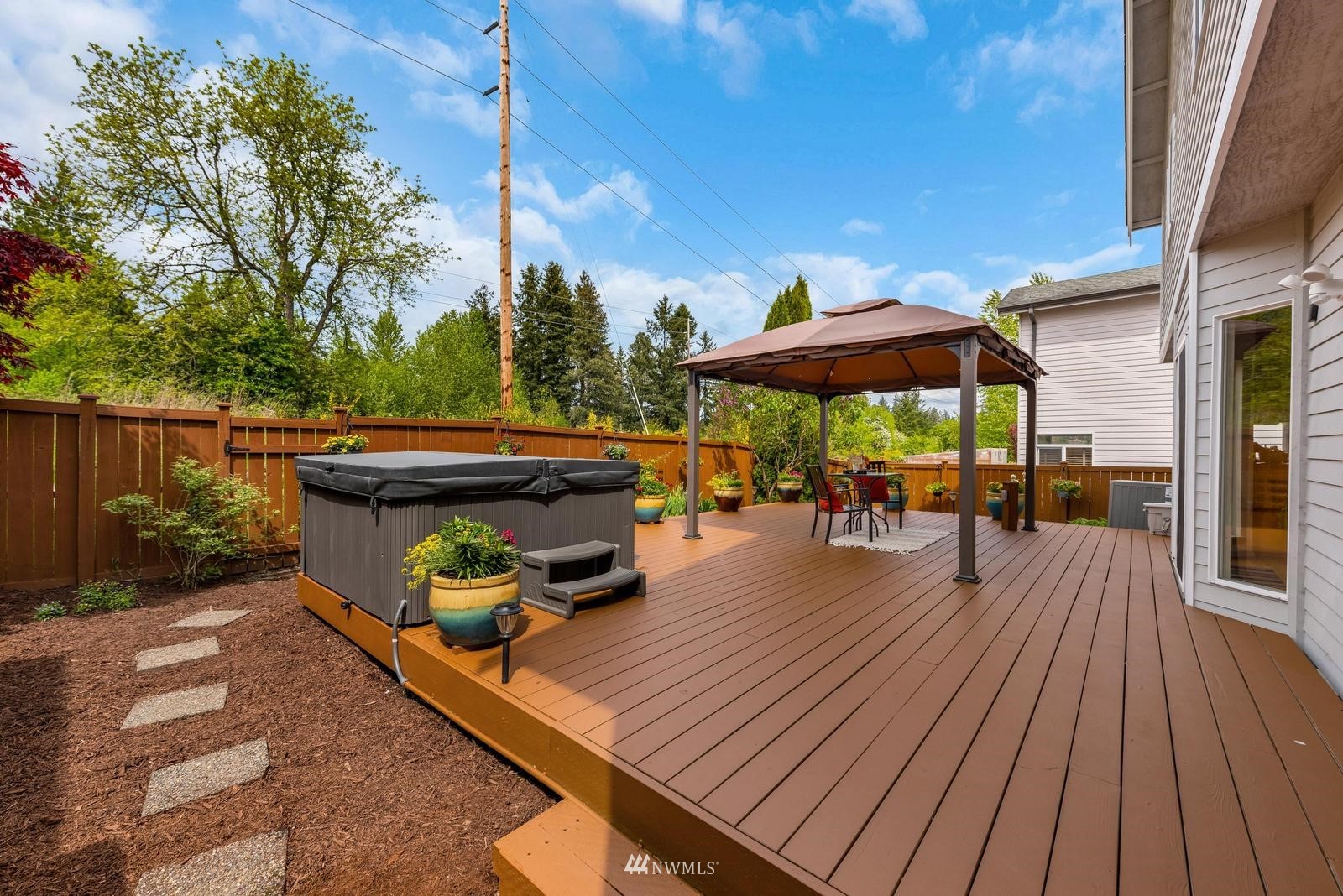 16218 Southeast 249th Place Covington, WA 98042 - Photo 32 of 38 a view of a roof deck with table and chairs under an umbrella with wooden floor
