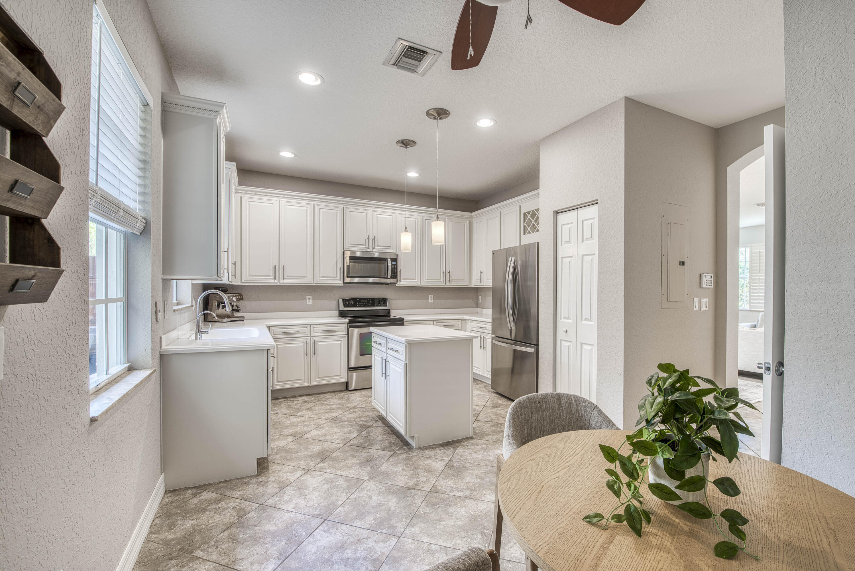 120 West Thatch Palm Circle Jupiter, FL 33458 - Photo 12 of 41 a kitchen with a refrigerator and white cabinets