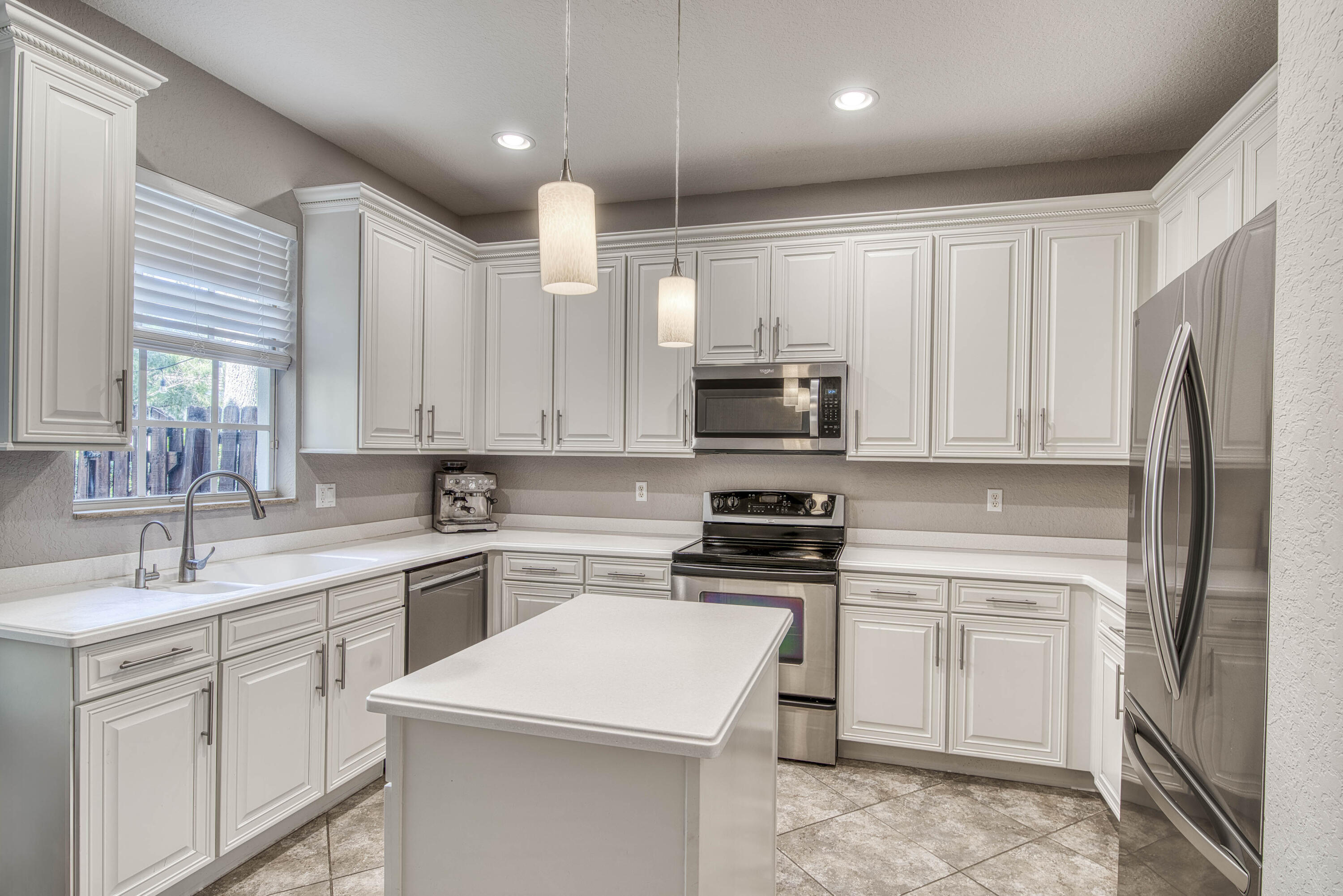 120 West Thatch Palm Circle Jupiter, FL 33458 - Photo 15 of 41 a kitchen with white cabinets stainless steel appliances and sink