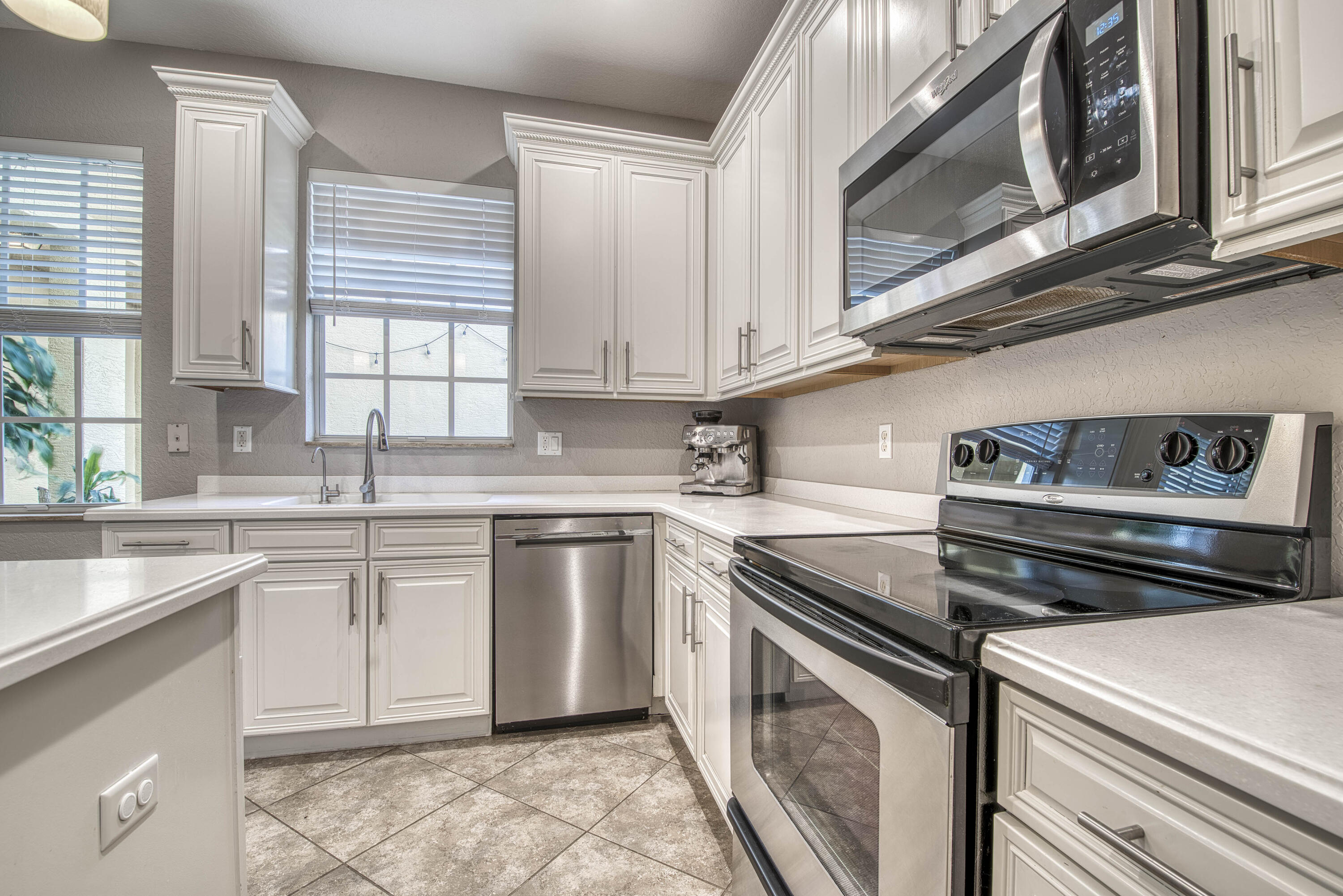 120 West Thatch Palm Circle Jupiter, FL 33458 - Photo 16 of 41 a kitchen with stainless steel appliances granite countertop a sink and cabinets