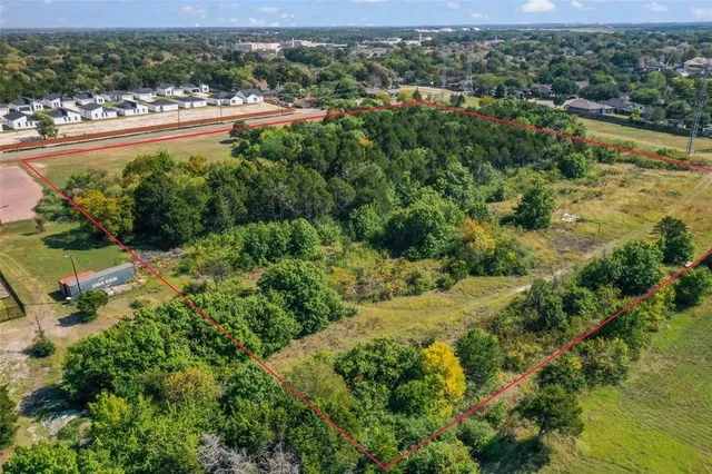 an aerial view of residential houses with outdoor space and trees