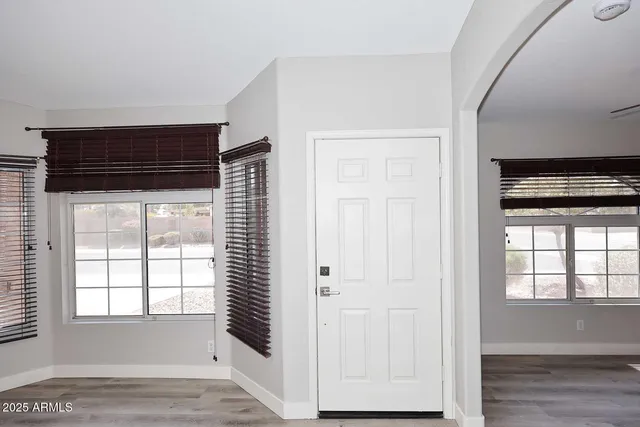 a view of empty room with wooden floor and windows