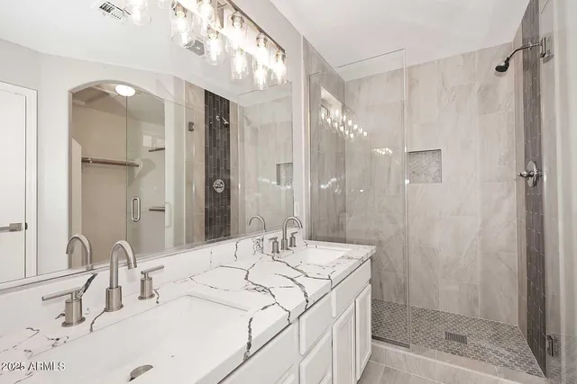 a bathroom with a granite countertop sink mirror and shower