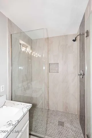 a bathroom with a granite countertop sink a shower and a mirror