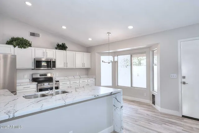 a kitchen with stainless steel appliances granite countertop a sink stove and refrigerator