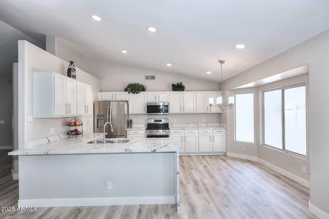 a view of kitchen with center island wooden floor and living room view