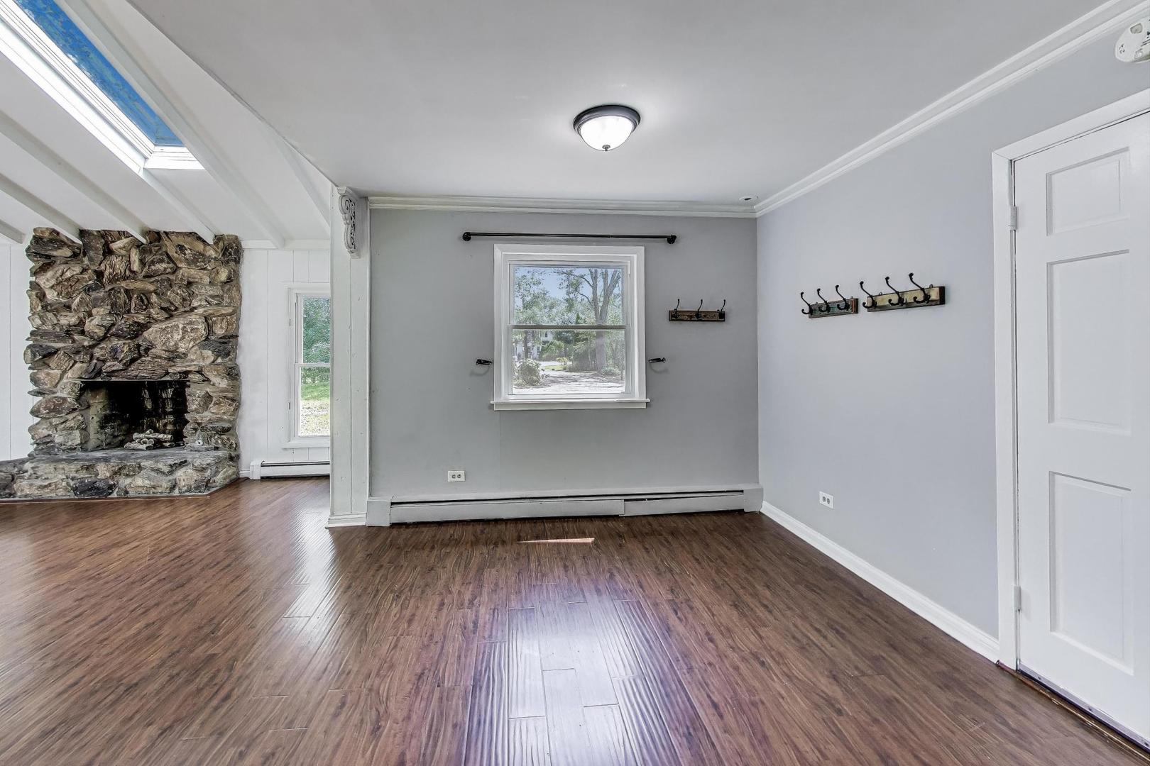 222 Bradwell Road Inverness, IL 60010 - Photo 17 of 46 an empty room with wooden floor fireplace and windows