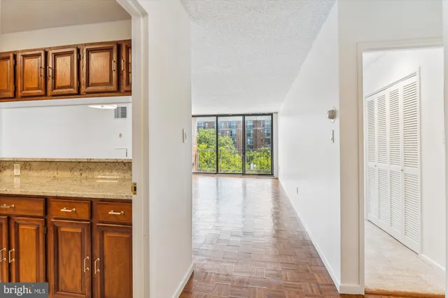 a view of hallway with wooden floor and cabinet