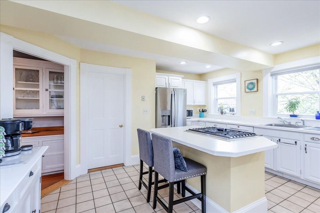 44 Baker Avenue, Unit 1 Beverly, MA 01915 - Photo 14 of 29 a kitchen with stainless steel appliances a table and chairs in it
