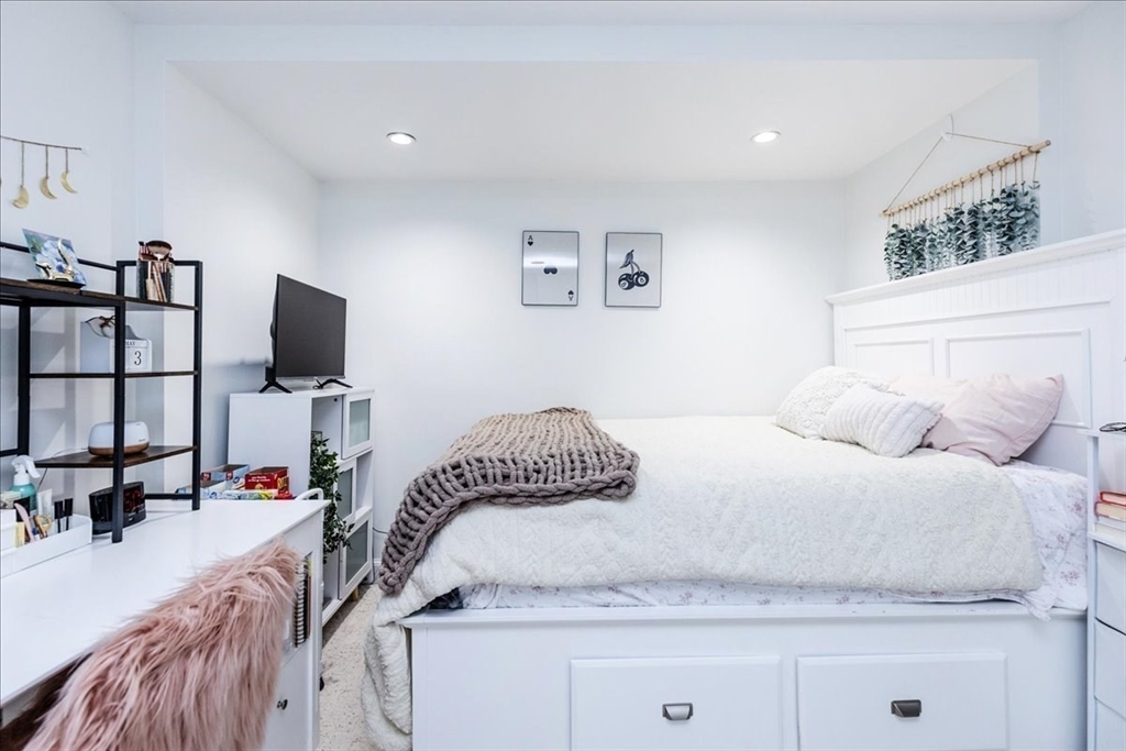 44 Baker Avenue, Unit 1 Beverly, MA 01915 - Photo 19 of 29 a bedroom with a bed and flat screen tv