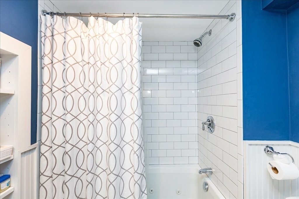 44 Baker Avenue, Unit 1 Beverly, MA 01915 - Photo 21 of 29 a bathroom with a shower curtain and a bathtub