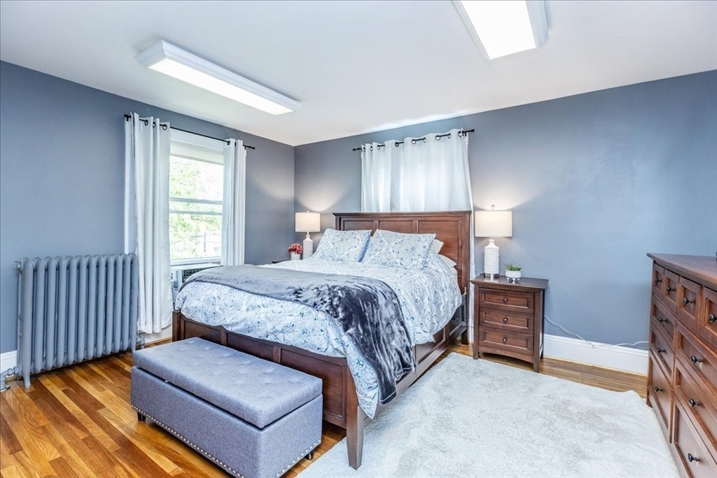 44 Baker Avenue, Unit 1 Beverly, MA 01915 - Photo 24 of 29 a bedroom with a bed and a couch