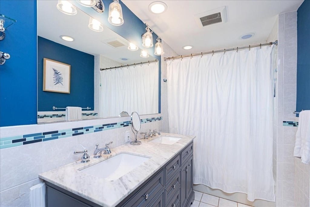44 Baker Avenue, Unit 1 Beverly, MA 01915 - Photo 26 of 29 a bathroom with a sink vanity and a mirror