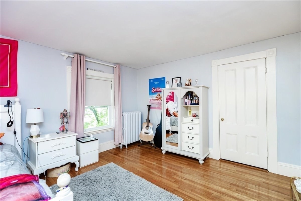 44 Baker Avenue, Unit 1 Beverly, MA 01915 - Photo 28 of 29 a view of a bedroom with baby crib and lounge chair