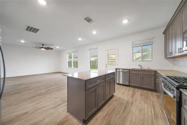 a kitchen with granite countertop a sink and cabinets