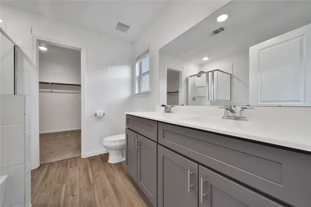 a bathroom with a double vanity sink toilet and a mirror